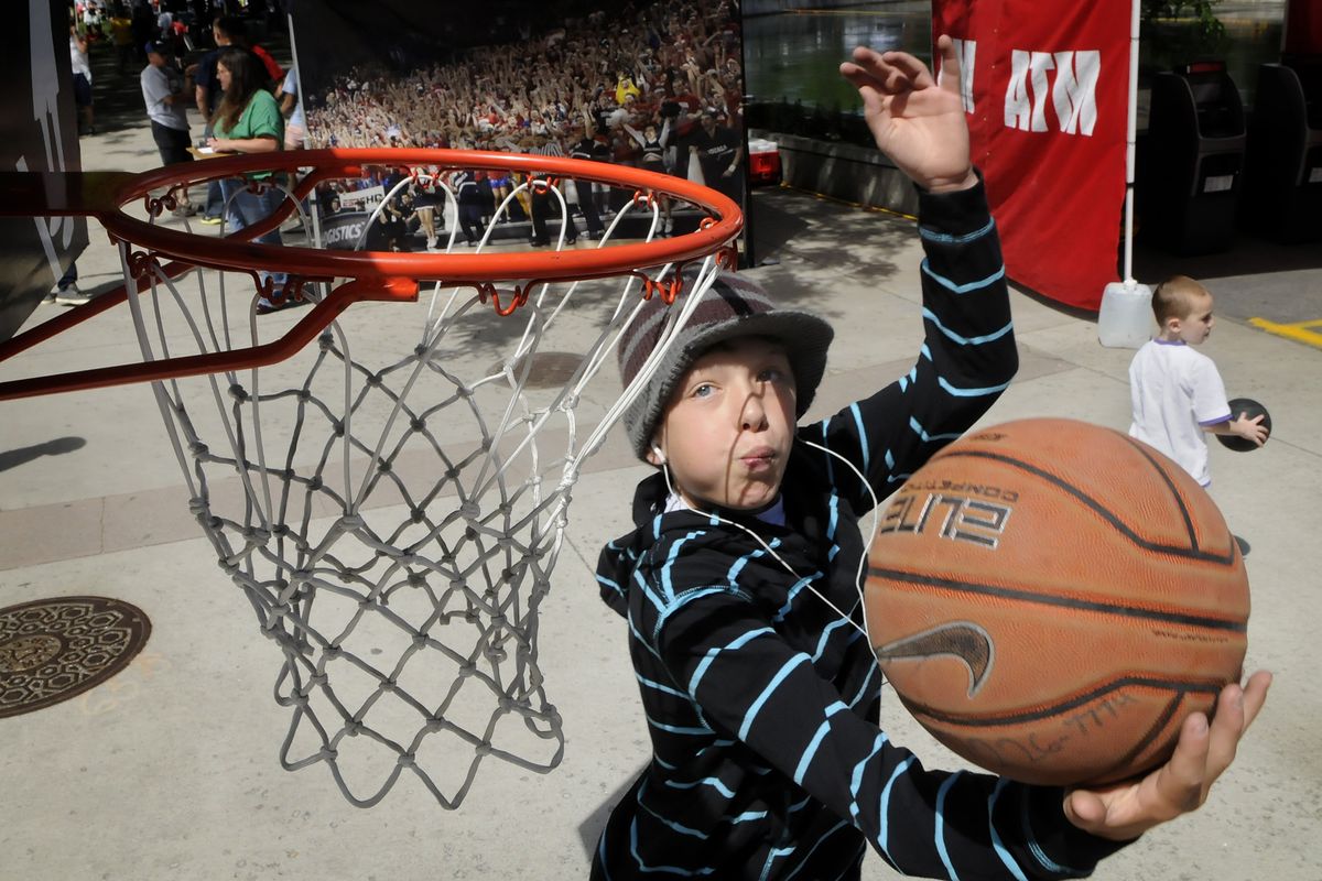 Quinlan Gray, 12, of Newcastle, Wash., demonstrates his reverse dunking skills on a short hoop after picking up his Hoopfest packet on Friday. More than 7,000 teams will hit the streets of downtown Spokane today as the annual three-on-three tournament begins. (Dan Pelle)