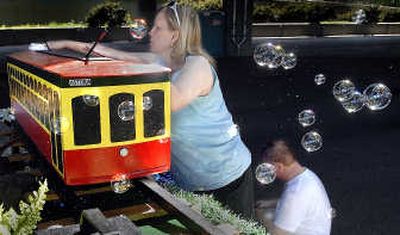 
Nancy Kennell wipes down a model trolley as Jim Larson works on the wiring of the Astoria, Ore., float Friday in the Lilac Parade staging area in west Spokane. 
 (CHRISTOPHER ANDERSON / The Spokesman-Review)