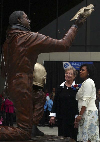 
Sculptor Dorothy Fowler, left, and Sandy Anderson look at the statue of Anderson's late husband, Michael P. Anderson, at its dedication Sunday in the breezeway between the Spokane Opera House and Convention Center. 
 (Liz-Anne Kishimoto / The Spokesman-Review)