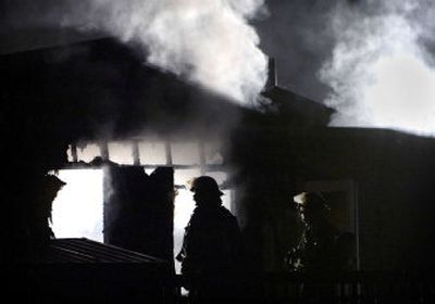 
Spokane Valley firefighters work to put out a blaze that broke out in a mobile home on North McMillan Drive on Friday evening.
 (Holly Pickett / The Spokesman-Review)