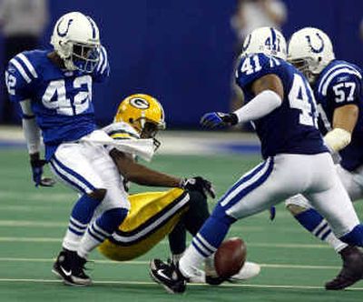 
Former WSU Cougar Jason David (42) of Indianapolis strips the ball from Green Bay receiver Javon Walker on Sunday. 
 (Associated Press / The Spokesman-Review)