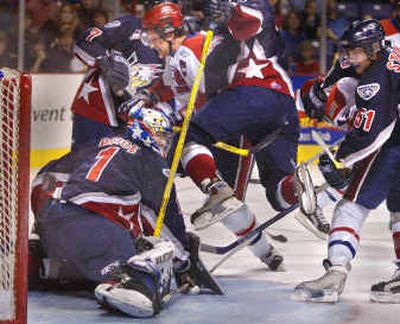 
Jevon Desautels of the Spokane Chiefs is slammed from behind by Tri-City Americans' Matt Schneider during first-period action Saturday.
 (Christopher Anderson/ / The Spokesman-Review)
