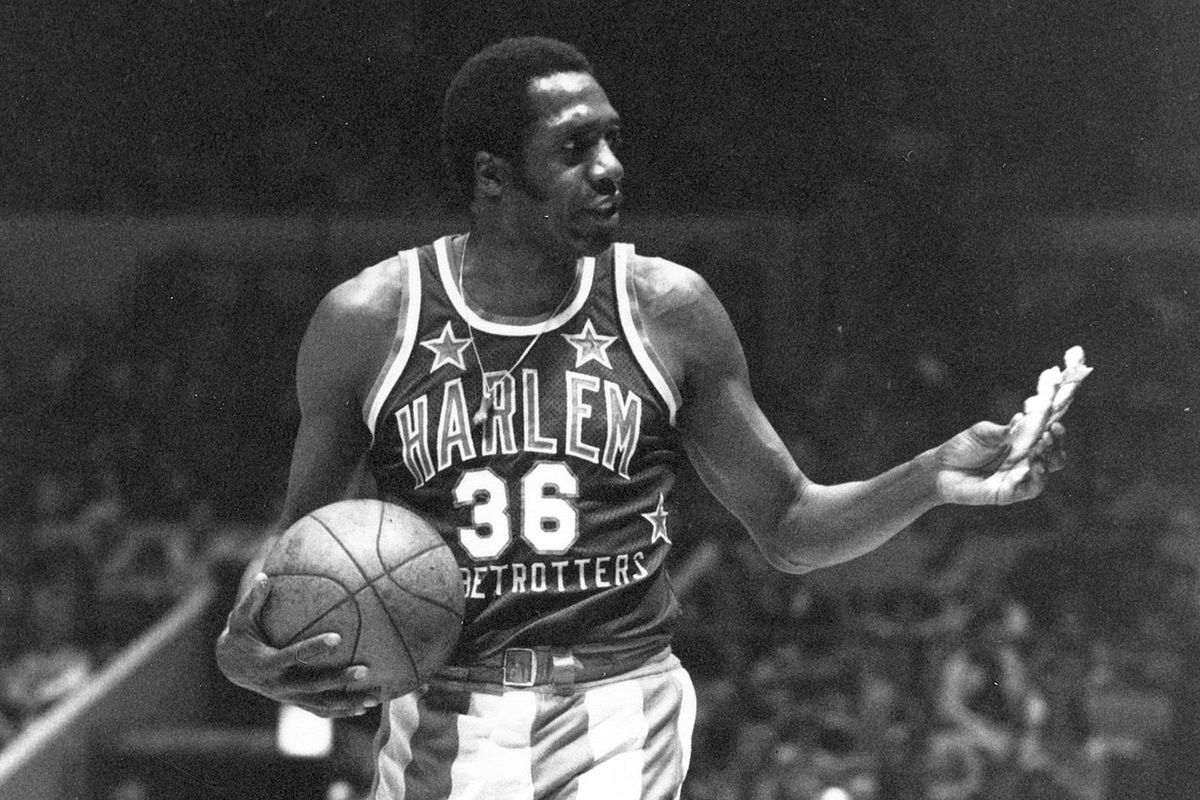 FILE - In this Feb. 18, 1978, file photo, Meadowlark Lemon, of the Harlem Globetrotters basketball team, offers a pretzel to a referee during a game at New York