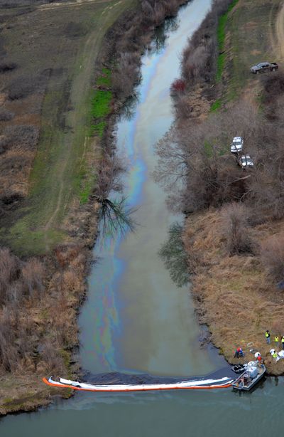 In this aerial photo taken Monday by the state Department of Ecology, boom tenders try to contain an oil spill on Sulphur Creek where it enters the Yakima River near Sunnyside, Wash. (Associated Press)