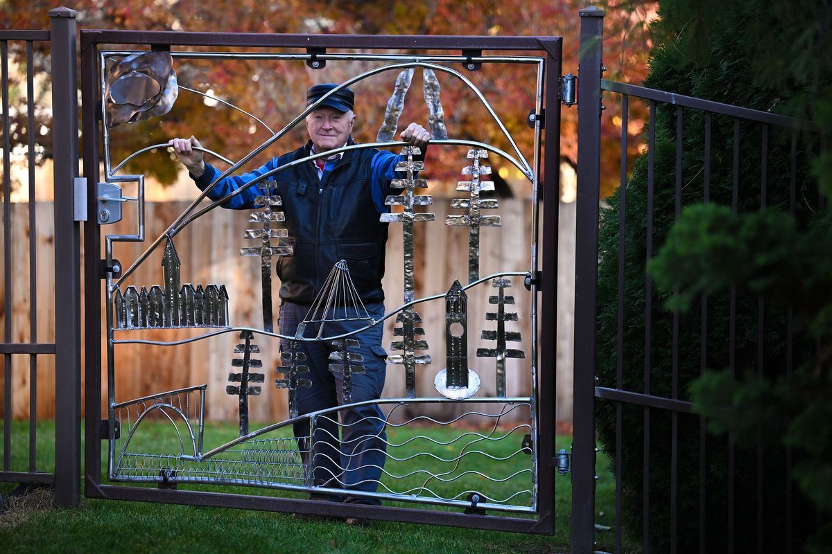 Tom Horne shows off the gate he created that features Spokane landmarks at his wife’s son’s home in Spokane. He was inspired by gates created by Sister Paula Mary Turnbull that are also on the property.  (Kathy Plonka/The Spokesman-Revie)