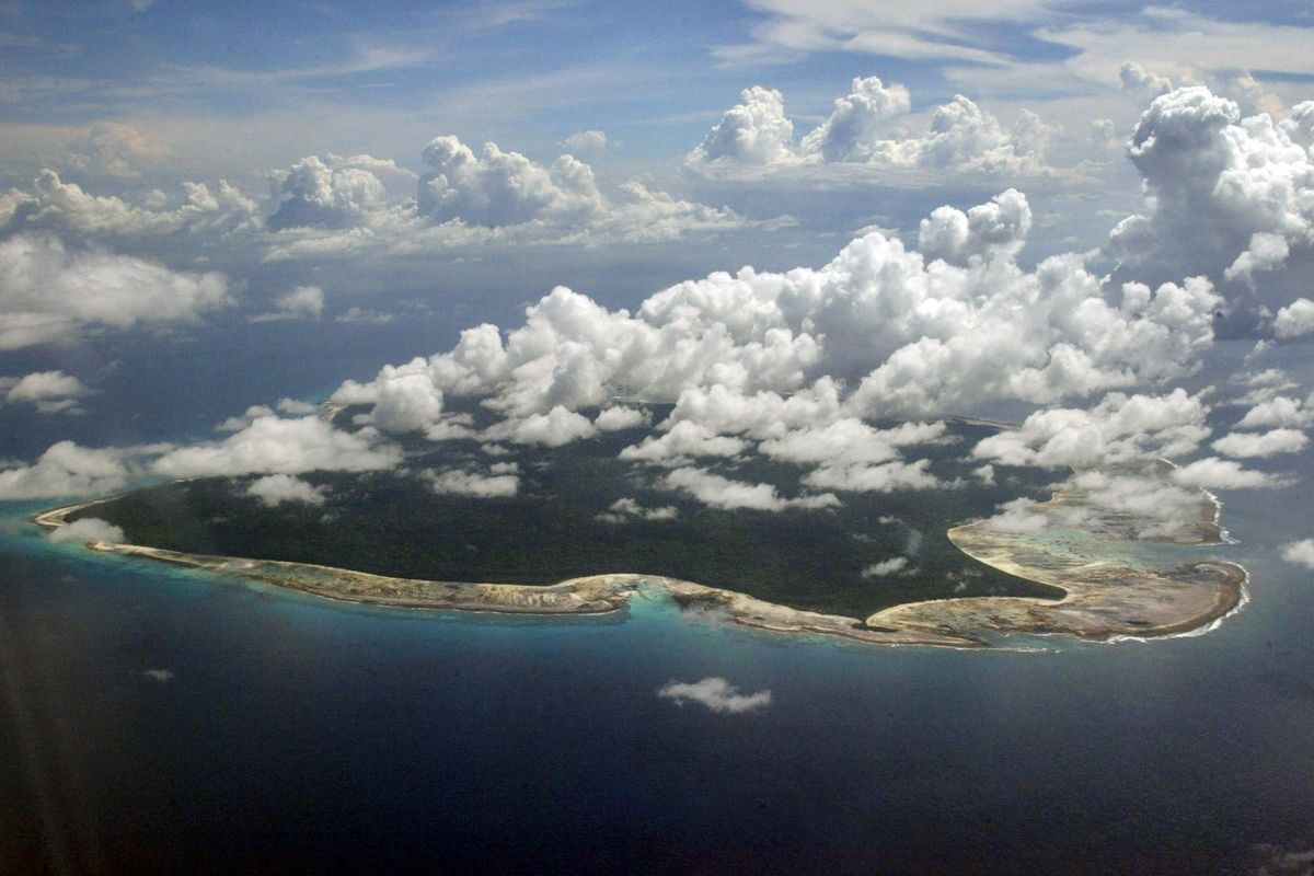 In this Nov. 14, 2005 file photo, clouds hang over the North Sentinel Island, in India’s southeastern Andaman and Nicobar Islands. An American is believed to have been killed by an isolated Indian island tribe known to fire at outsiders with bows and arrows, Indian police said Wednesday, Nov. 21, 2018. Police officer Vijay Singh said seven fishermen have been arrested for facilitating the American’s visit to North Sentinel Island, where the killing apparently occurred. Visits to the island are heavily restricted by the government. (Gautam Singh / AP)