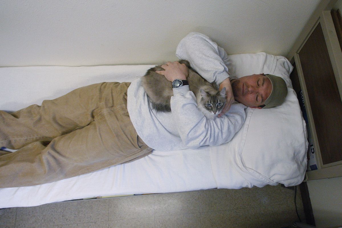 Inmate Richard Amaro holds Clementine in his 12-by-10-foot cell, which resembles a dormitory room, at Larch Correctional Facility in Yacolt, Wash. (AP/Rick Bowmer)