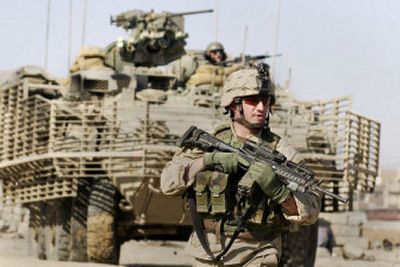 
A U.S.  soldier walks ahead of an armored Stryker combat vehicle  in Mosul, Iraq, in January 2005. The U.S. top commander in Iraq, Gen. George W. Casey Jr., said Saturday about 3,700 troops of the 172nd Stryker Brigade will move from northern Iraq to Baghdad. 
 (file Associated Press / The Spokesman-Review)