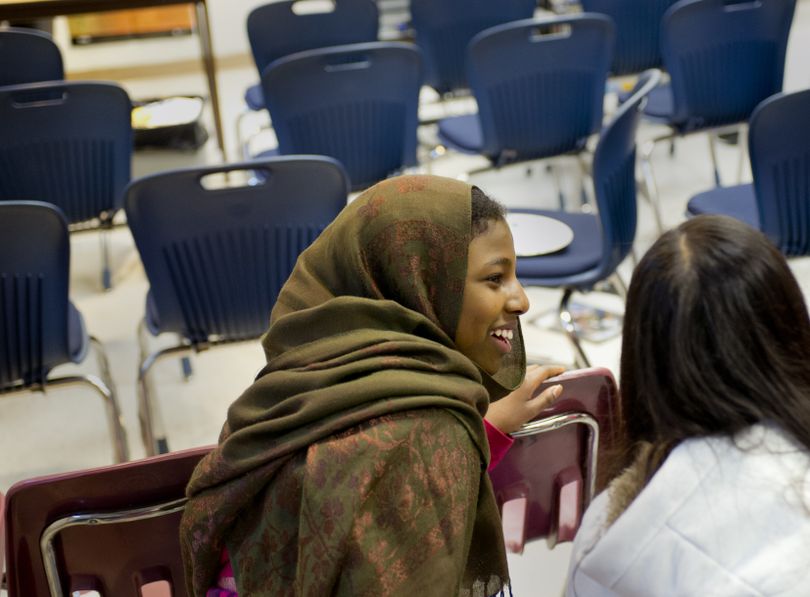 North Pines Middle School eighth-grader Asha Abbas, 14, left, and seventh-grader Isabella Moua, 13, share a laugh Wednesday after an English language development class presentation in which students tell stories about themselves using Microsoft Photo Story. (Tyler Tjomsland)