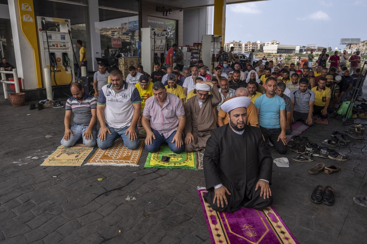 Muslim worshippers pray during Friday prayers at a gas station to protest severe fuel shortages that Lebanon has been witnessing for weeks, in the coastal town of Jiyeh, south of Beirut, Lebanon, Friday, Sept. 3, 2021. Lebanon is mired in a devastating economic and financial crisis, the worst in its modern history. A result of this has been crippling power cuts and severe shortages in gasoline and diesel that have been blamed on smuggling, hoarding and the cash-strapped government’s inability to secure deliveries of oil products.  (Hassan Ammar)
