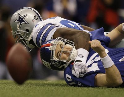 Giants QB Eli Manning fumbles after being sacked by DeMarcus Ware of the Cowboys. Dallas had eight sacks.  (Associated Press / The Spokesman-Review)