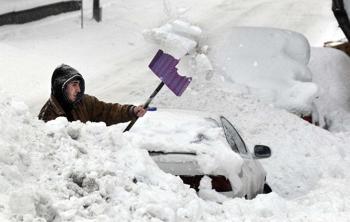 Mike Terry  spent more than two hours freeing his Acura from a snow berm Friday near Eighth Avenue and McClellan Street in Spokane.   (Dan Pelle / The Spokesman-Review)