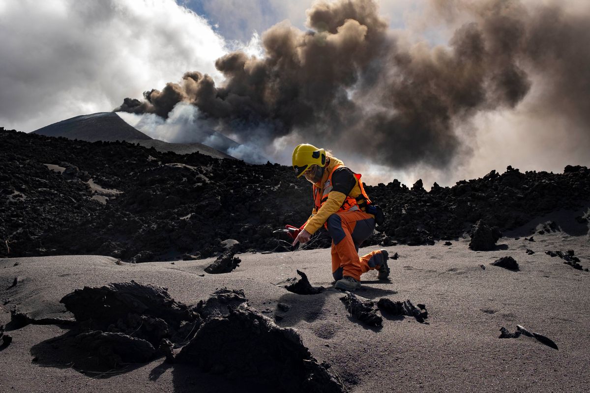 A scientist from IGME-CSIC (Geological and Mining Institute of Spain from Spanish National Research Council) measures the temperature of lava near a volcano on the Canary island of La Palma, Spain, Sunday, Nov. 5, 2021. Scientists from around the world flocking to an eastern Atlantic Ocean island are using an array of new technologies available to them in 2021 to scrutinize — from land, sea, air, and even space — a rare volcanic eruption.  (Taner Orribo)