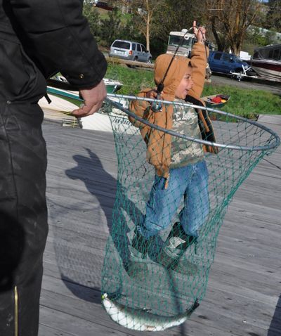 A rookie angler celebrates catching his first trout on opening day off the docks at Fishtrap Lake Resort.