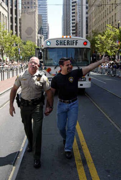 
San Francisco sheriff's deputies Kevin Hever, left, and Michael Sousa march in the 34th-annual gay-pride parade in San Francisco on Sunday. The two had been planning to get married during the wave of same-sex marriages in February and March but were unable to do so because of work commitments. 
 (Associated Press / The Spokesman-Review)