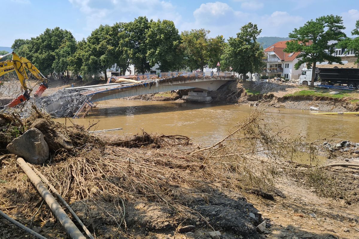 Workers use heavy machines to tear down a damaged bridge in the flood-hit town of Ahrweiler, Germany, on Friday, July 23, 2021. With the death toll and economic damage from last week’s floods in Germany continuing to rise, questions have been raised about why systems designed to warn people of the impending disaster didn’t work.  (Frank Jordans)