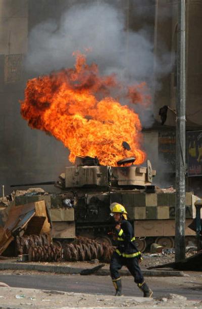 
A firefighter runs as a U.S. military vehicle burns after being struck by a bomb Saturday in the Sadr City area of Baghdad. No U.S. casualties were reported.
 (Associated Press / The Spokesman-Review)