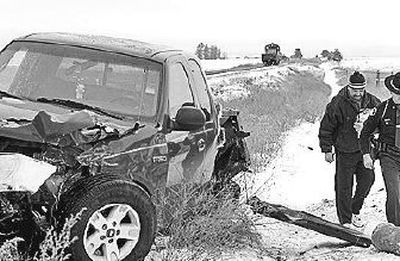 
The driver of the pickup that hit a train walks with an Idaho State Police trooper by his damaged truck near the tracks in Post Falls.
 (Jesse Tinsley / The Spokesman-Review)