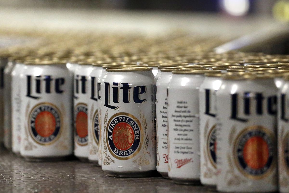 Newly filled and sealed cans of Miller Lite beer move along on a conveyor belt at the MillerCoors Brewery, in Golden, Colo. After turning down five offers, British-based brewer SABMiller, which sells beers including Miller Lite, Coors Light and Blue Moon in the U.S. and Puerto Rico through a joint venture with Molson Coors, accepted in principle an improved takeover bid worth 69 billion pounds ($106 billion) from Anheuser Busch InBev. Many analysts think that the merged company will be compelled to sell the Miller line of beers in the U.S. (Brennan Linsley / File Associated Press)