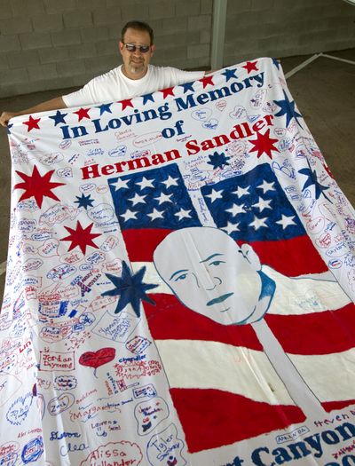Kevin Held displays a section of a never-finished 9/11 memorial quilt at a storage facility in Gilbert, Ariz., on Aug. 22. The $713,000 Held raised to create the massive quilt is gone; more than $270,000 went to Held and family members. (Associated Press)