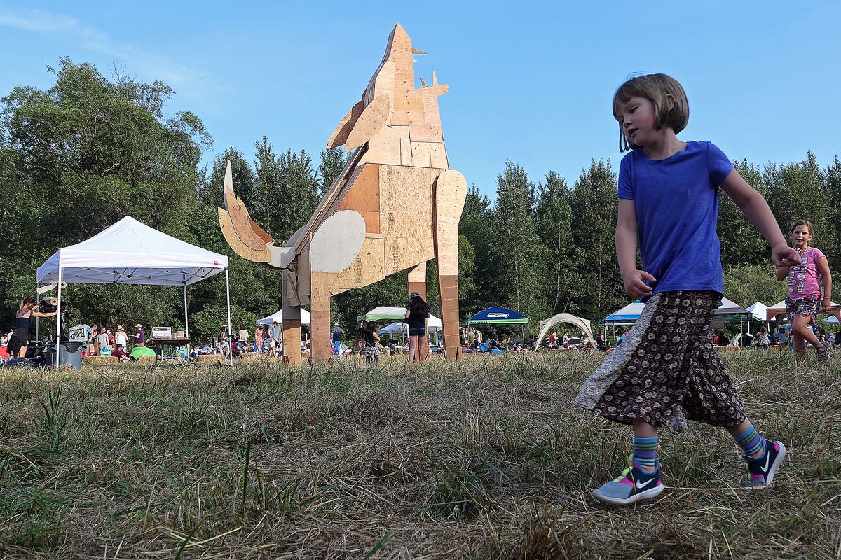 Attendees enjoy the scene at Burning Beast as the sun sets over this year's mascot, a coyote. At the end of the festival, the mascot is set on fire. (John Nelson)