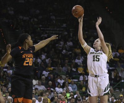 Baylor forward Lauren Cox (15) shoots past Oklahoma State center Mariam Gnanou (15) during Saturday’s game. Baylor won 76-44. (Jerry Larson / Associated Press)