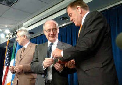 
Secretary of Homeland Security Tom Ridge, right, exchanges pens with Irish Ambassador Noel Fahey, middle, as European Union Ambassador Gunter Burghardt looks on after they signed an agreement to allow collection of airline passenger data, in Washington on May 28. 
 (File/Associated Press / The Spokesman-Review)