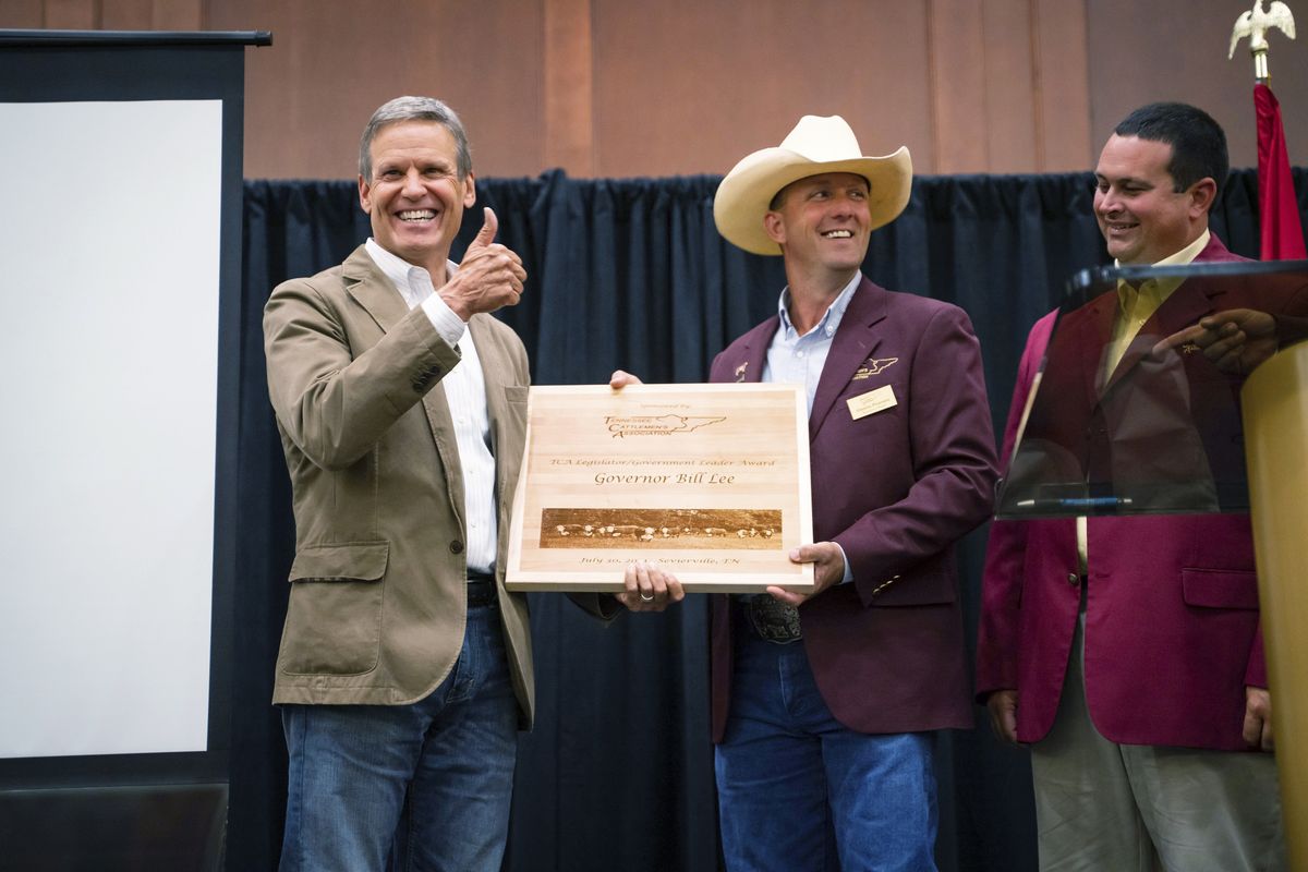 This photo provided by the State of Tennessee shows Tennessee Gov. Bill Lee receiving an award from Dustin Pearson, Tennessee Cattlemen’s Association President-Elect at the Tennessee Cattlemen’s Association annual convention on July 30, 2021 in Sevierville, Tenn. Despite having some of the lowest COVID-19 vaccination rates in the country, Tennessee isn’t planning to offer any incentives for people to get the shot. But it’s a different story when it comes to cattle, where the state has reimbursed farmers nearly half a million dollars over the past two years to vaccinate their herds against respiratory and other diseases. At right is Jay Yeargin, Tennessee Cattlemen’s Association President.  (HOGP)