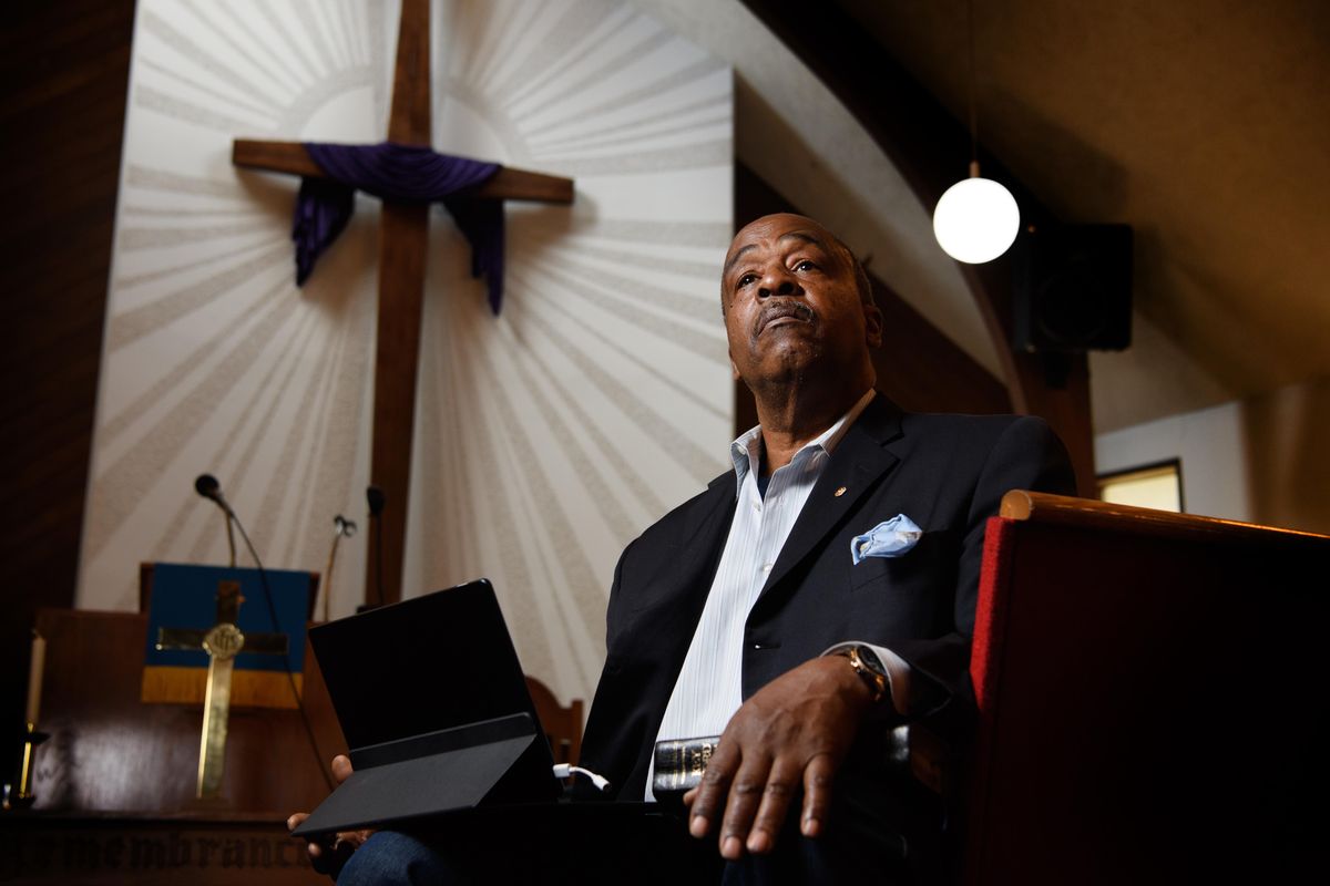 Rev. Walter Kendricks of Morning Star Baptist Church poses for a photo with his Bible on one knee and the computer he will use to live-stream his Easter Sunday service to members on the other on Tuesday, April 7, 2020, at Morning Star Baptist Church in Spokane, Wash. (Tyler Tjomsland / The Spokesman-Review)
