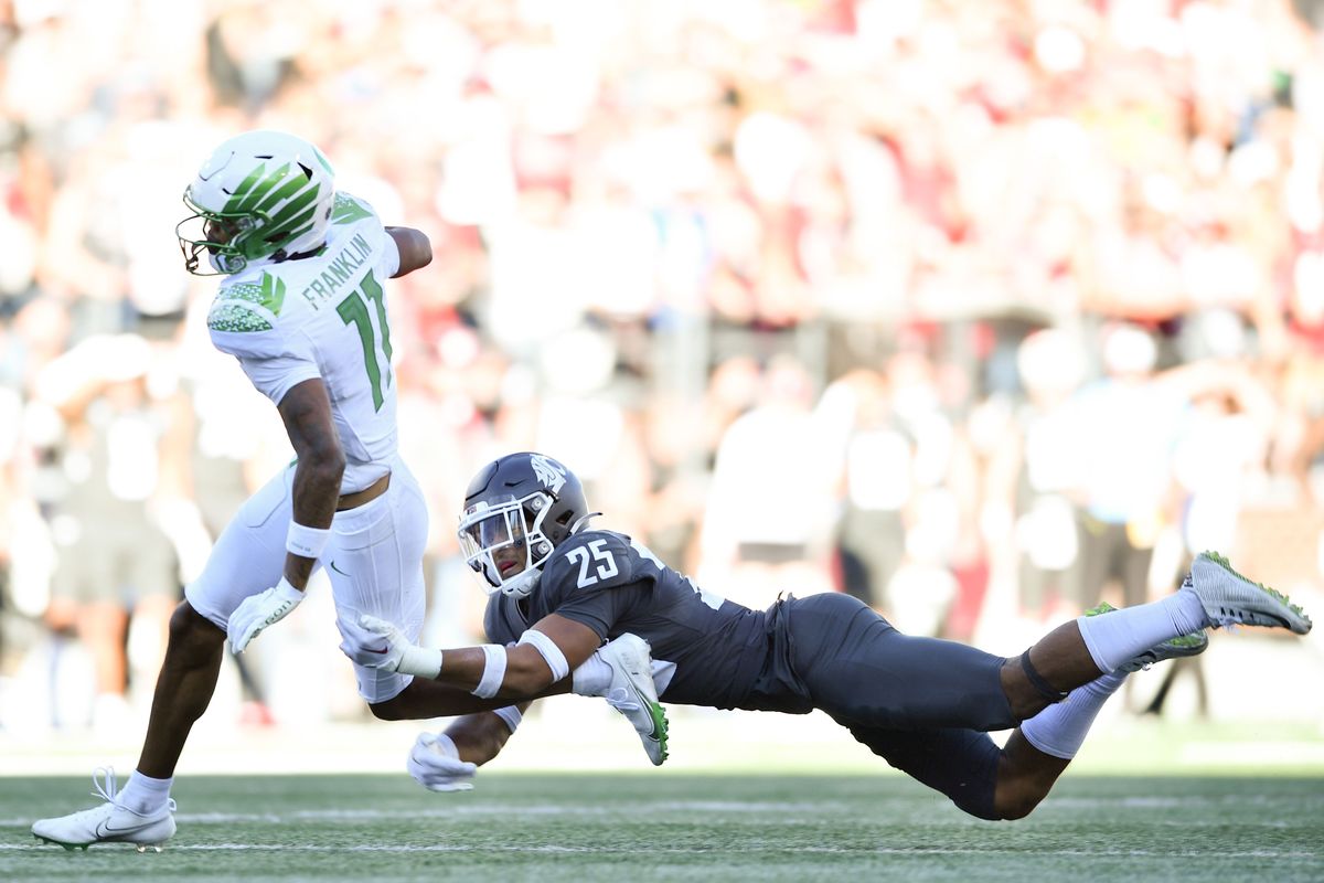 Oregon Ducks wide receiver Troy Franklin (11) slips a tackle from Washington State Cougars defensive back Jaden Hicks (25) and runs for a touchdown during the second half of a college football on Saturday, Sept. 24, 2022, at Martin Stadium in Pullman, Wash. Oregon won the game 44-41.  (Tyler Tjomsland / The Spokesman-Review)