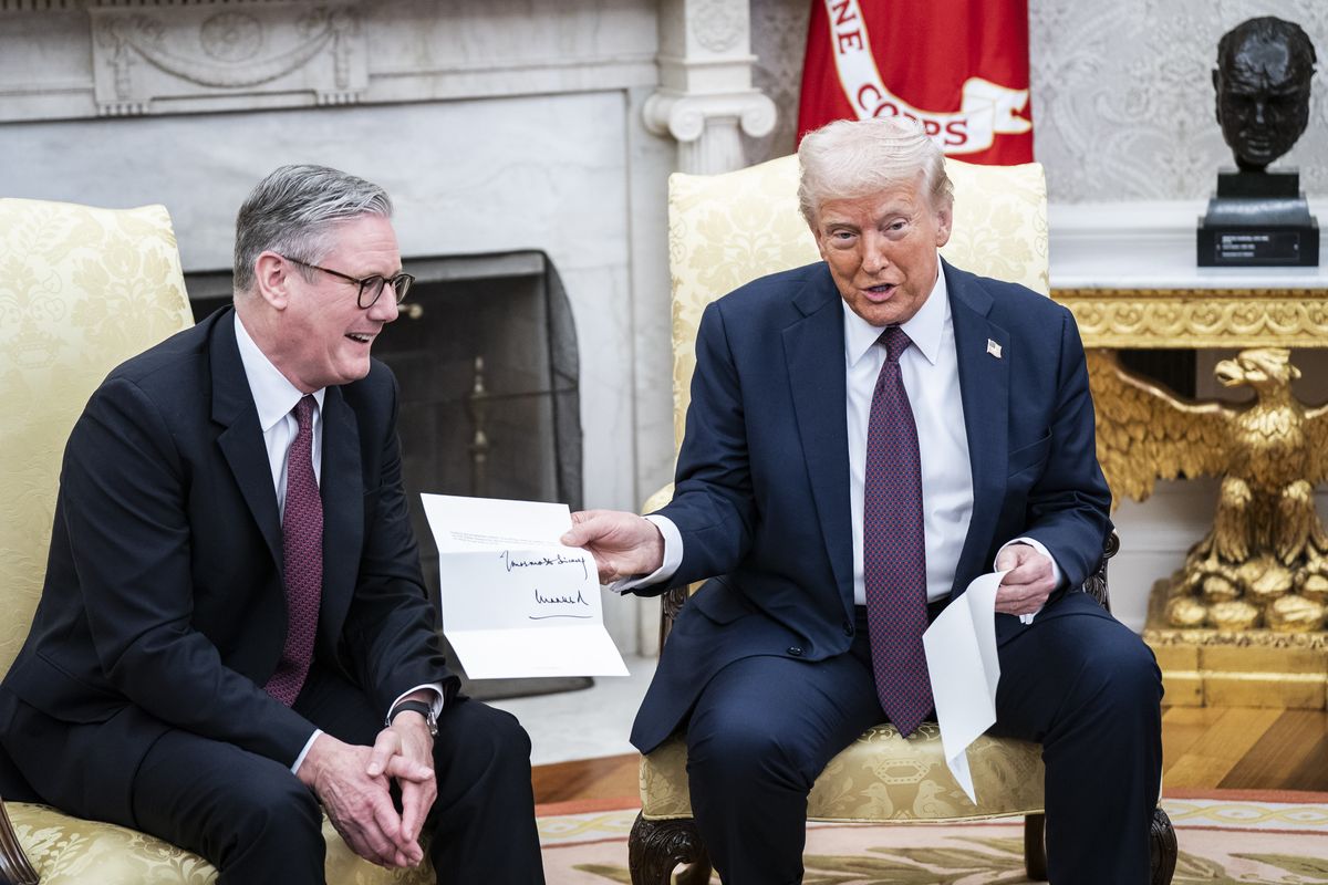 President Donald Trump is given a letter from King Charles III by British Prime Minister Keir Starmer in the Oval Office at the White House on Feb. 27. (Jabin Botsford/The Washington Post)