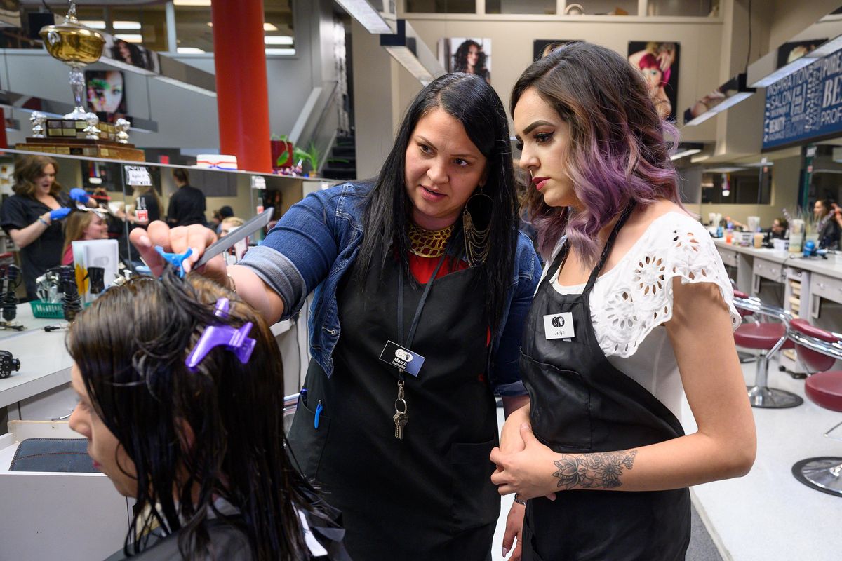 Glen Dow Academy instructor Mandi Doucoure, center, gives  suggestions to cosmetology student Jazlynn Bedolla, right, about how best to cut client Brandi White’s hair, Wednesday, July 3, 2019. Glen Dow Academy is celebrating its 50th anniversary this month. (Colin Mulvany / The Spokesman-Review)
