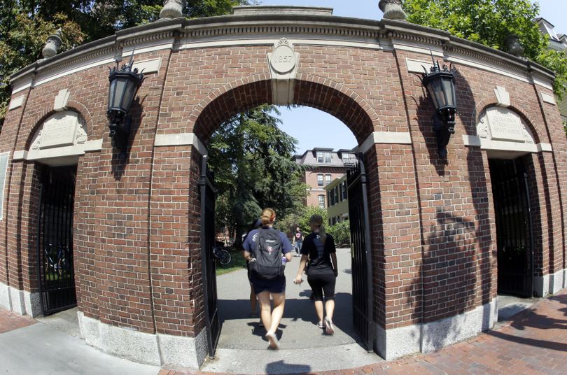 Pedestrians walk through a gate on the campus of Harvard University in Cambridge, Mass. Thursday, Aug. 30, 2012. Dozens of Harvard University students are being investigated for cheating after school officials discovered evidence they may have wrongly shared answers or plagiarized on a final exam. Harvard officials on Thursday didn't release the class subject, the students' names, or specifically how many are being investigated. (Elise Amendola / Associated Press)