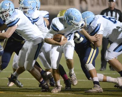 Central Valley QB Tanner Sloan, center, goes on the run, but his head is whipped backwards by a Mead facemask, Friday, Oct. 1, 2015 at Joe Albi Stadium. It was a penalty which took the Bears closer to the goal line in the second quarter where they scored. (Jesse Tinsley)