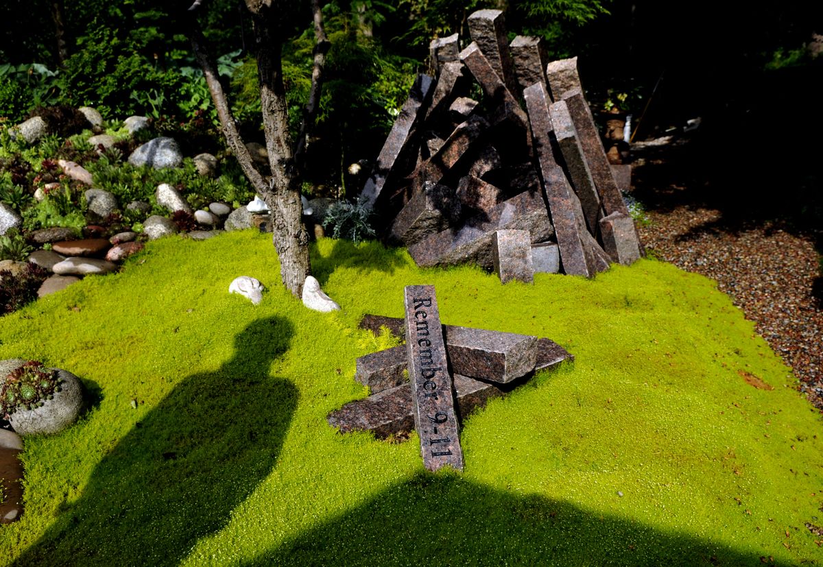 kathypl@spokesman.com Gardener Paul Walker of Hayden, Idaho stands next to his tribute to the Sept. 11 terrorist attacks. His garden is part of this year’s Coeur d’Alene Garden Tour. (Kathy Plonka / The Spokesman-Review)
