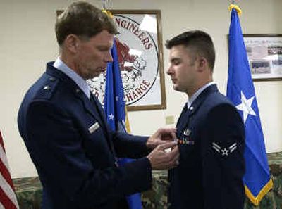 
During a medal ceremony at Fairchild Air Force Base, Airman 1st Class. Brandon Guingrich receives the Purple Heart from visiting Brig. Gen Del Eulberg. Guingrich sustained injuries in Iraq from a remotely detonated explosive device while on patrol last December. 
 (Colin Mulvany / The Spokesman-Review)