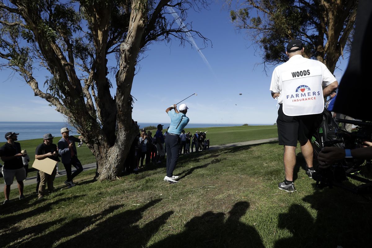 Tiger Woods hits a tree as he hits his second shot on the 16th hole of the north course at Torrey Pines Golf Course during the pro-am event at the Farmers Insurance Open golf tournament, Wednesday, Jan. 24, 2018, in San Diego. (Gregory Bull / Associated Press)