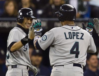 Jose Lopez, right, celebrates with Ichiro Suzuki after hitting his third home run of the game. (Associated Press)