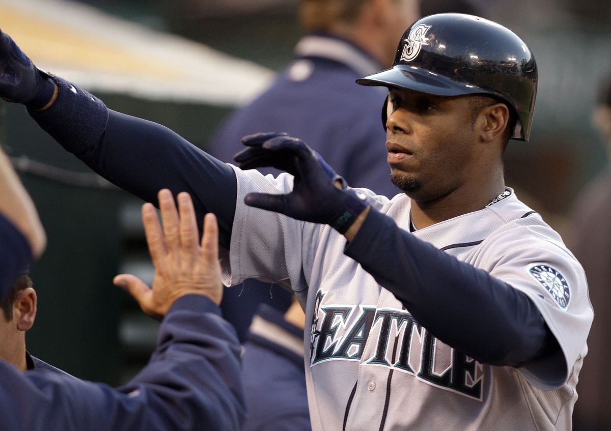 Seattle’s Ken Griffey Jr. is congratulated after scoring in the second inning.  (Associated Press / The Spokesman-Review)