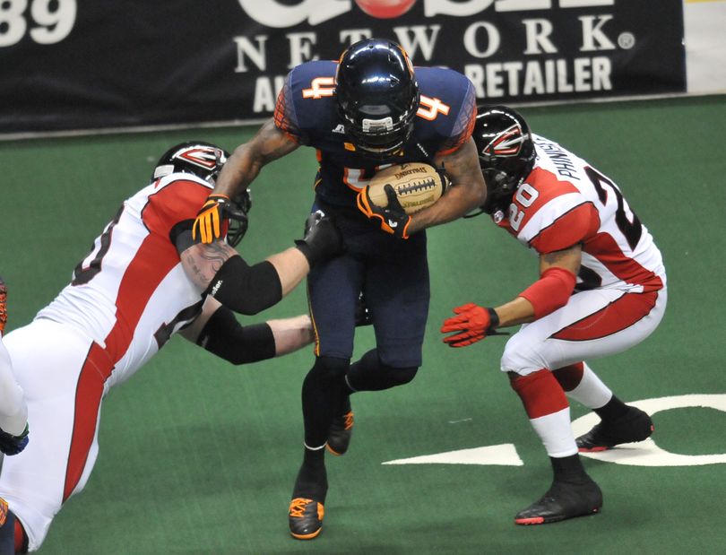 Spokane Shock's return specialist, Ruschard Dodd-Masters, center, tries to dance between Cleveland Gladiators' Russell Monk,  left, and Joe Phinisee, right, on a return run on Saturday, March 19, 2011, at the Spokane Arena. (Jesse Tinsley / The Spokesman-Review)