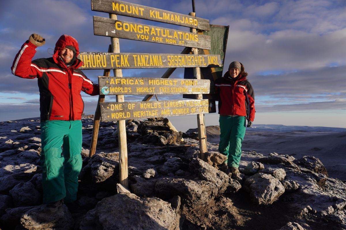 Simon Spencer and Emily Gillespie stand at the peak of Mount Kilimanjaro in Tanzania. (Emily Gillespie / For The Washington Post)