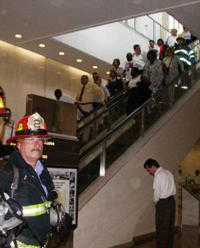 
Sgt. John Sheehan, of Fire Patrol 2 in Manhattan, stands guard as occupants evacuate Tower One during the attacks on the World Trade Center in New York City in this Sept. 11, 2001, photograph.
 (File/Associated Press / The Spokesman-Review)