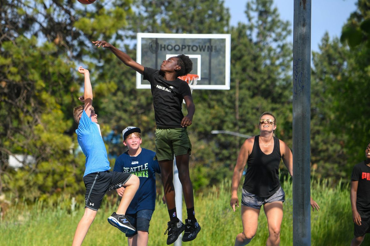 Sadrian Sartoe rises to block a shot by Dalton Terry, left, as Colton Fox, Audrey Terry and Arisha Sartoe watch on the Thorton Murphy basketball court on June 7. Audrey is coaching the boy’s Hoopfest team named “Dead to Me.” Sadrian will play on a different team during Hoopfest.  (DAN PELLE/THE SPOKESMAN-REVIEW)