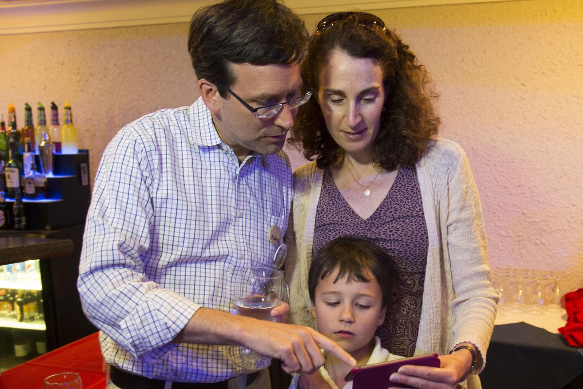 State Attorney General Bob Ferguson, who is running for re-election, looks for early results with his wife Colleen and son, Jack, 8, at the Lincoln Center in Spokane. He easily topped his only challenger. (Colin Mulvany / The Spokesman-Review)