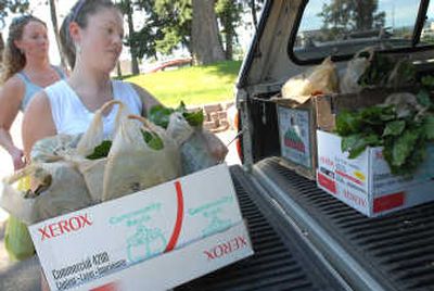 
Kelly Garasky, left, and Korrine Kreilkamp load leftover lettuce from the Kootenai Farmers' Market into their truck. 
 (JESSE TINSLEY Photos / The Spokesman-Review)