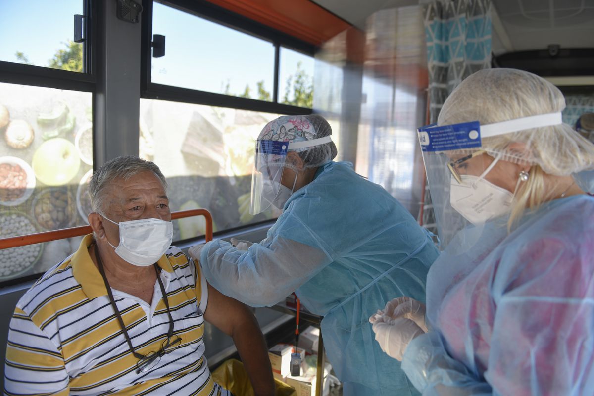 LEFT: A man receives the Johnson & Johnson vaccine Sept. 4 in a bus that serves as a mobile COVID-19 vaccination unit in Bucharest, Romania.  (Andreea Alexandru)