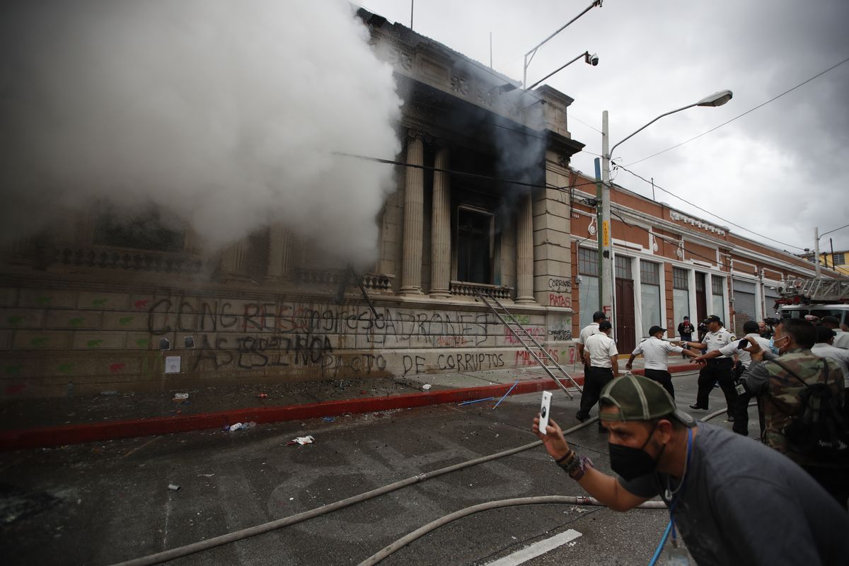 Clouds of smoke shoot out from the Congress building after protesters set it on fire, in Guatemala City, Saturday, Nov. 21, 2020. Hundreds of protesters were protesting in various parts of the country Saturday against Guatemalan President Alejandro Giammattei and members of Congress for the approval of the 2021 budget that reduced funds for education, health and the fight for human rights. (Moises Castillo)