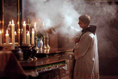 
Father John, a Franciscan priest, waves incense over an altar at the 13th Station of the Cross, believed to be the Golgotha, or place where Jesus was crucified, inside the Church of the Holy Sepulchre in Jerusalem, in 1999. 
 (File/Associated Press / The Spokesman-Review)