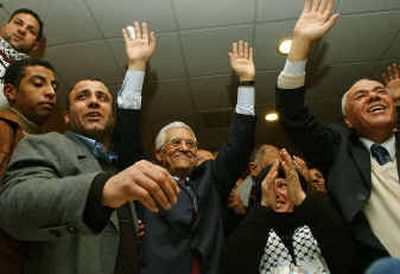 
Mahmoud Abbas, also known as Abu Mazen, center, celebrates with supporters and aides in the West Bank city of Ramallah on Sunday after exit polls indicated he won the Palestinian presidential elections. 
 (Associated Press / The Spokesman-Review)