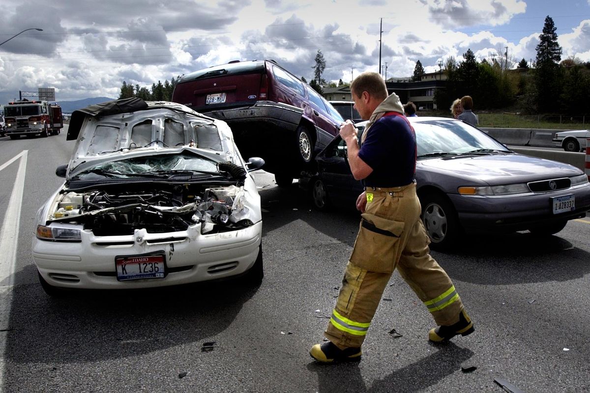 Valley firefighter David Phay investigates a three-car pile up on Interstate 90 near Pines Road on April 19, 2004. (Steve  Thompson / The Spokesman-Review)